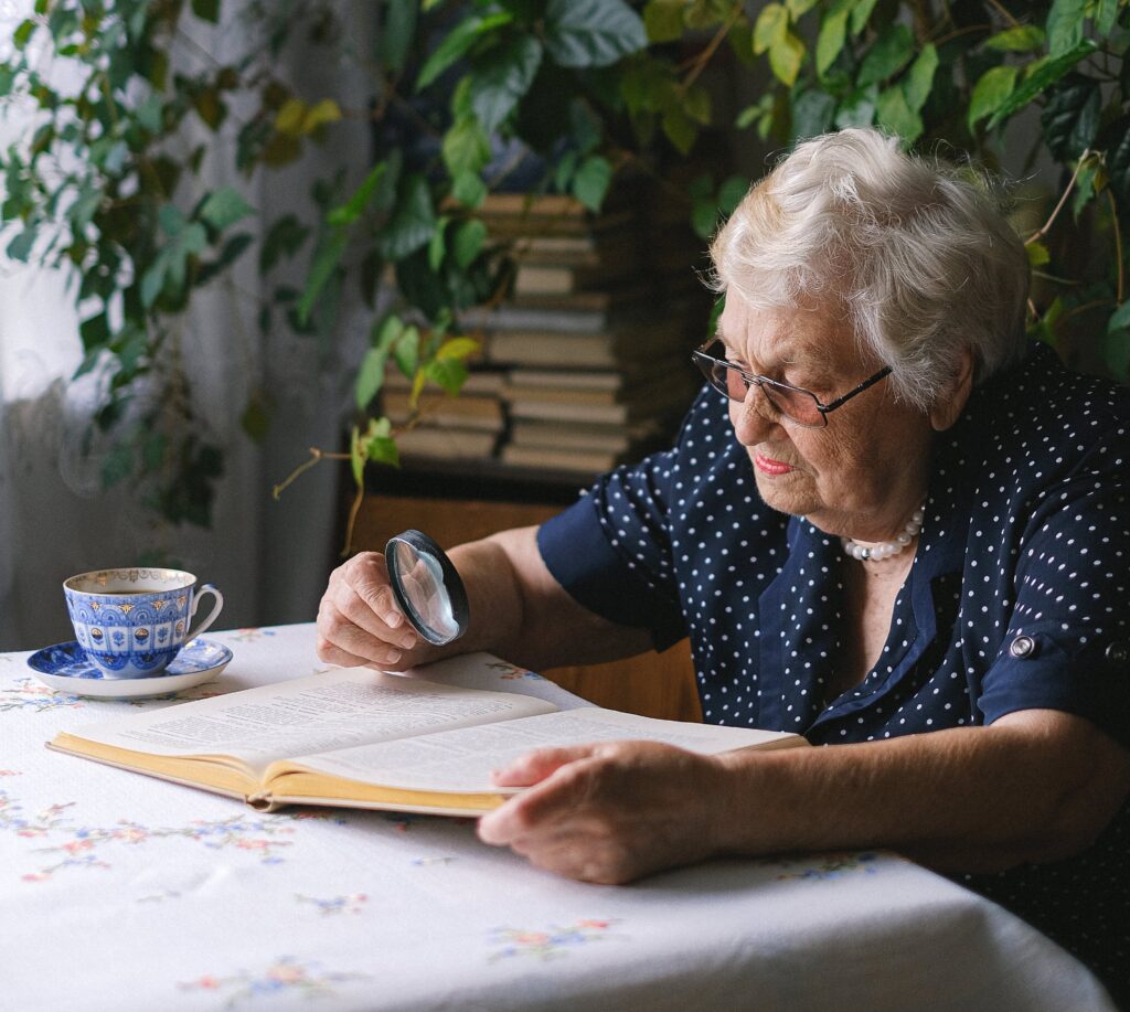 woman reading a book with a magnifying glass