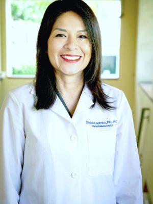 Dr. Casimiro smiling in her white coat.